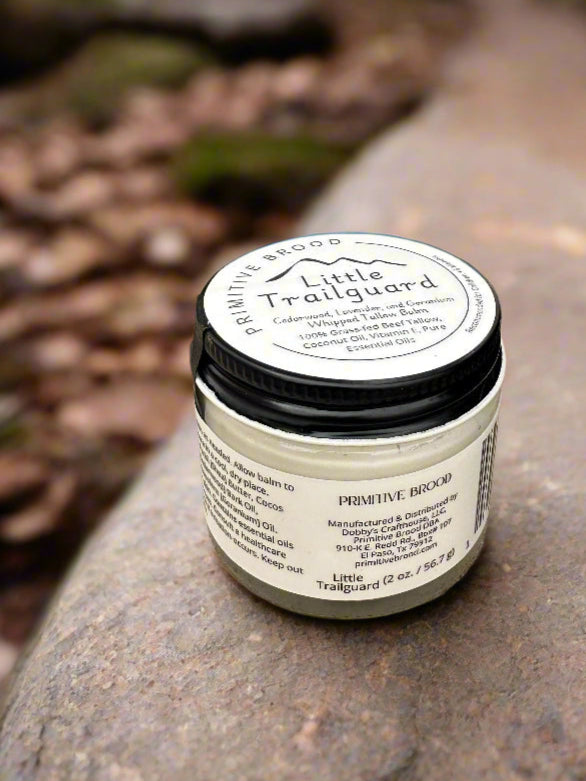 Jar of Little Trailguard on a forested hiking trail.